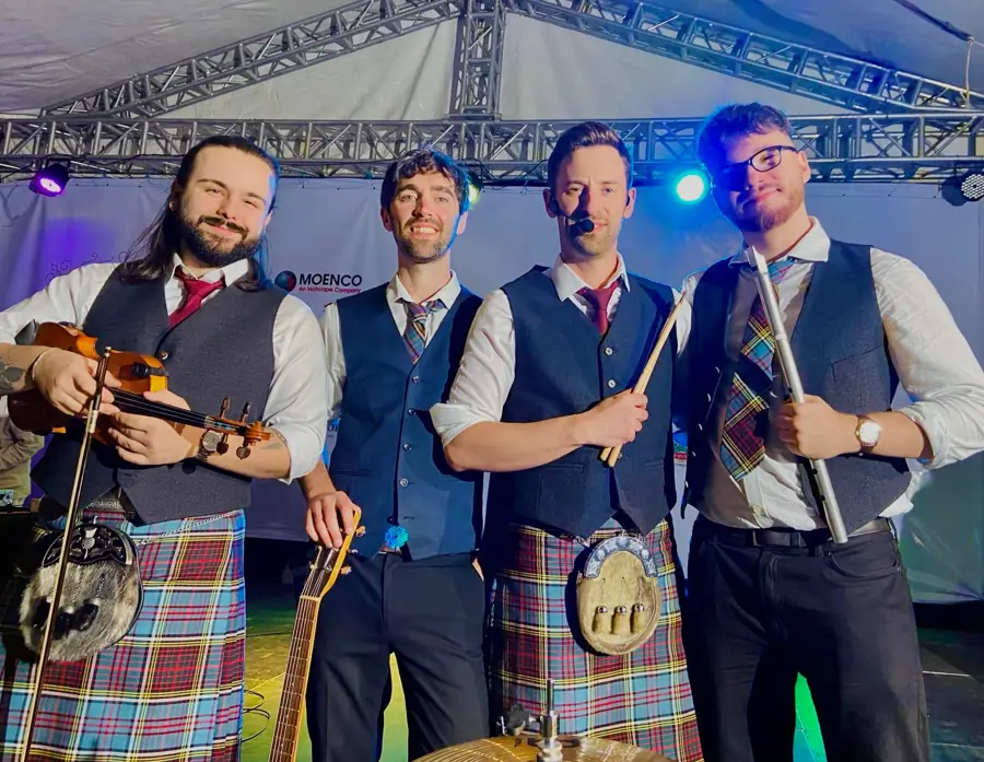 The Sassenachs on stage in kilts with fiddle, guitar and flute